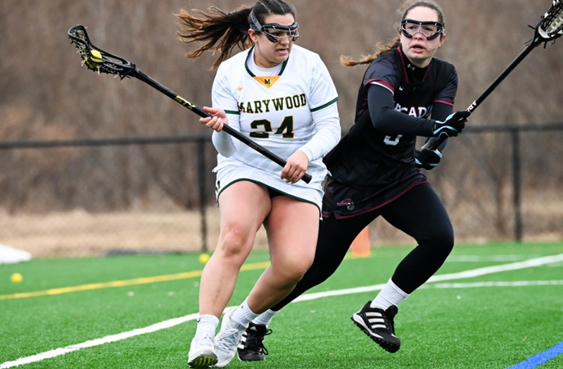 A Marywood field hockey player catching a ball.